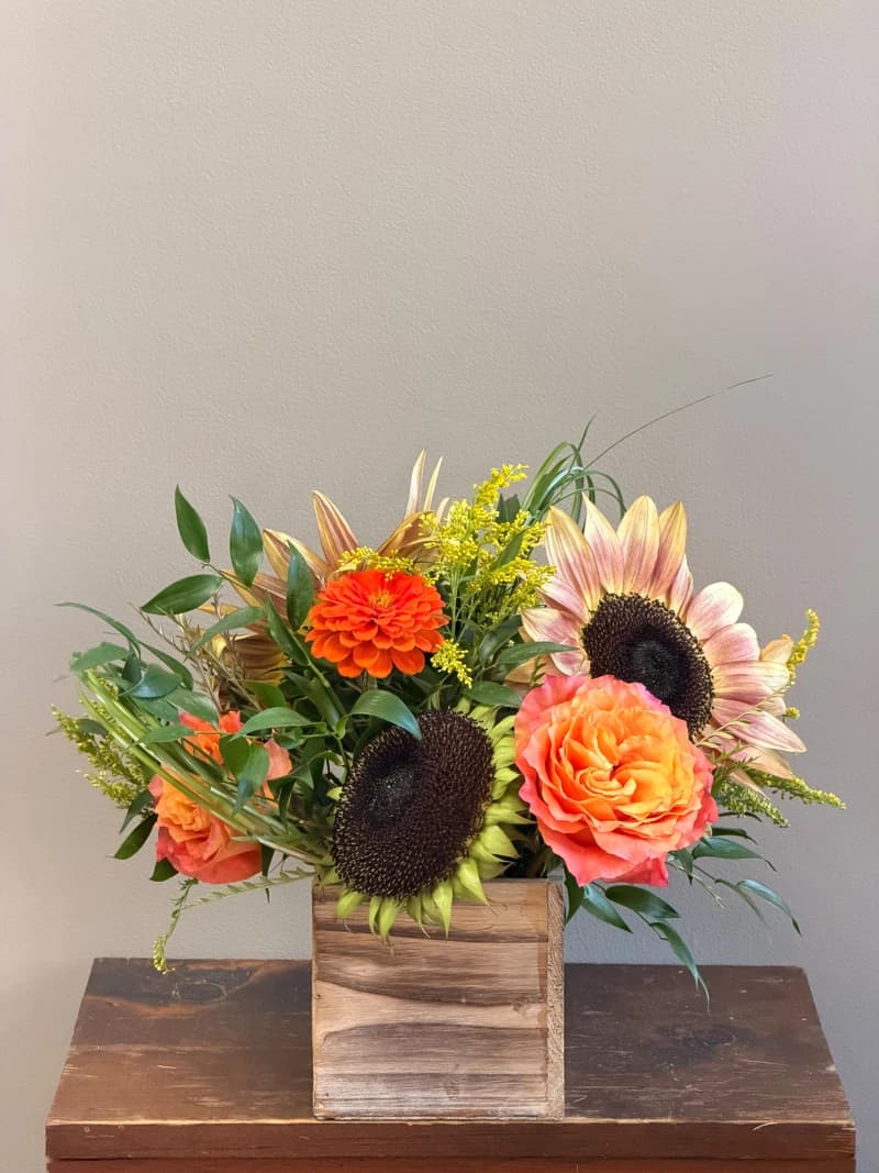 A rustic wooden box overflowing with warm autumn color.