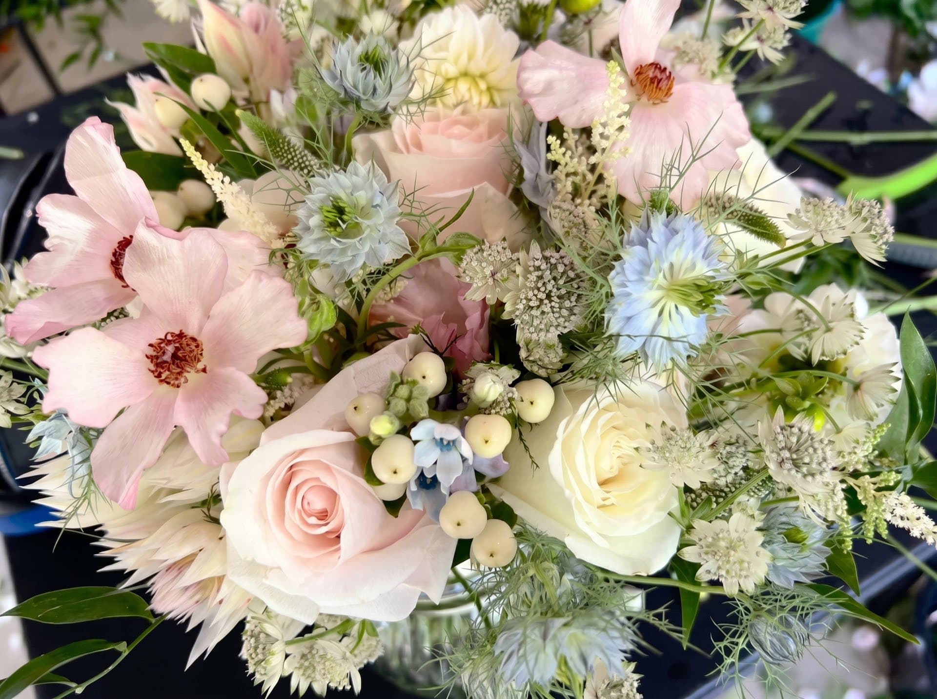 A large, full arrangement of garden roses and seasonal stems.